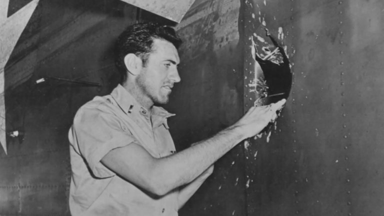 Louis Zamperini mostrando un boquete realizado en un B-24D Liberator